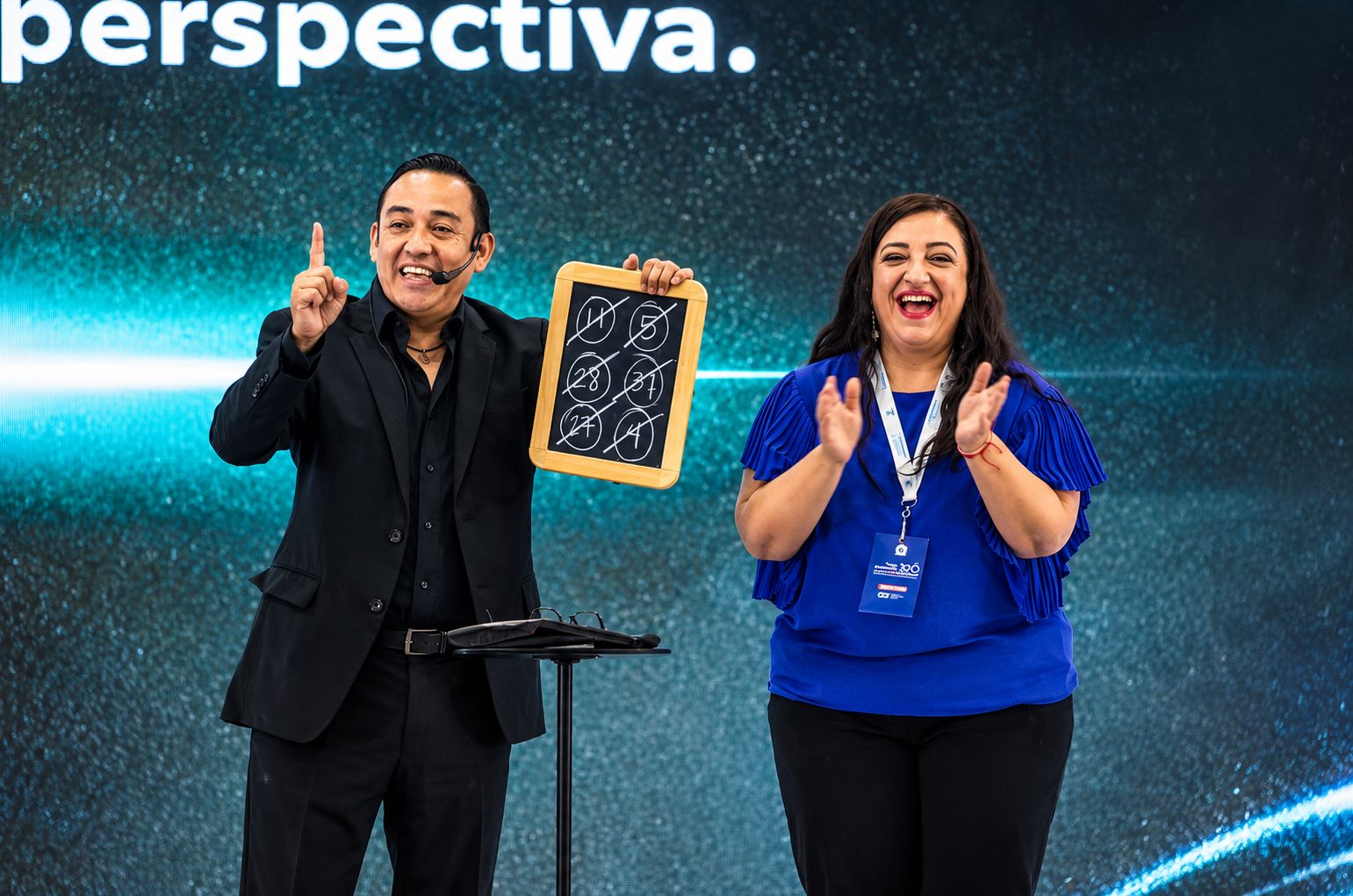 Ale Estrello en el escenario con una participante del público