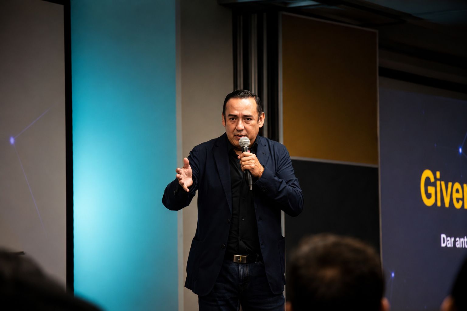 Ale Estrello en el escenario con micrófono durante una conferencia