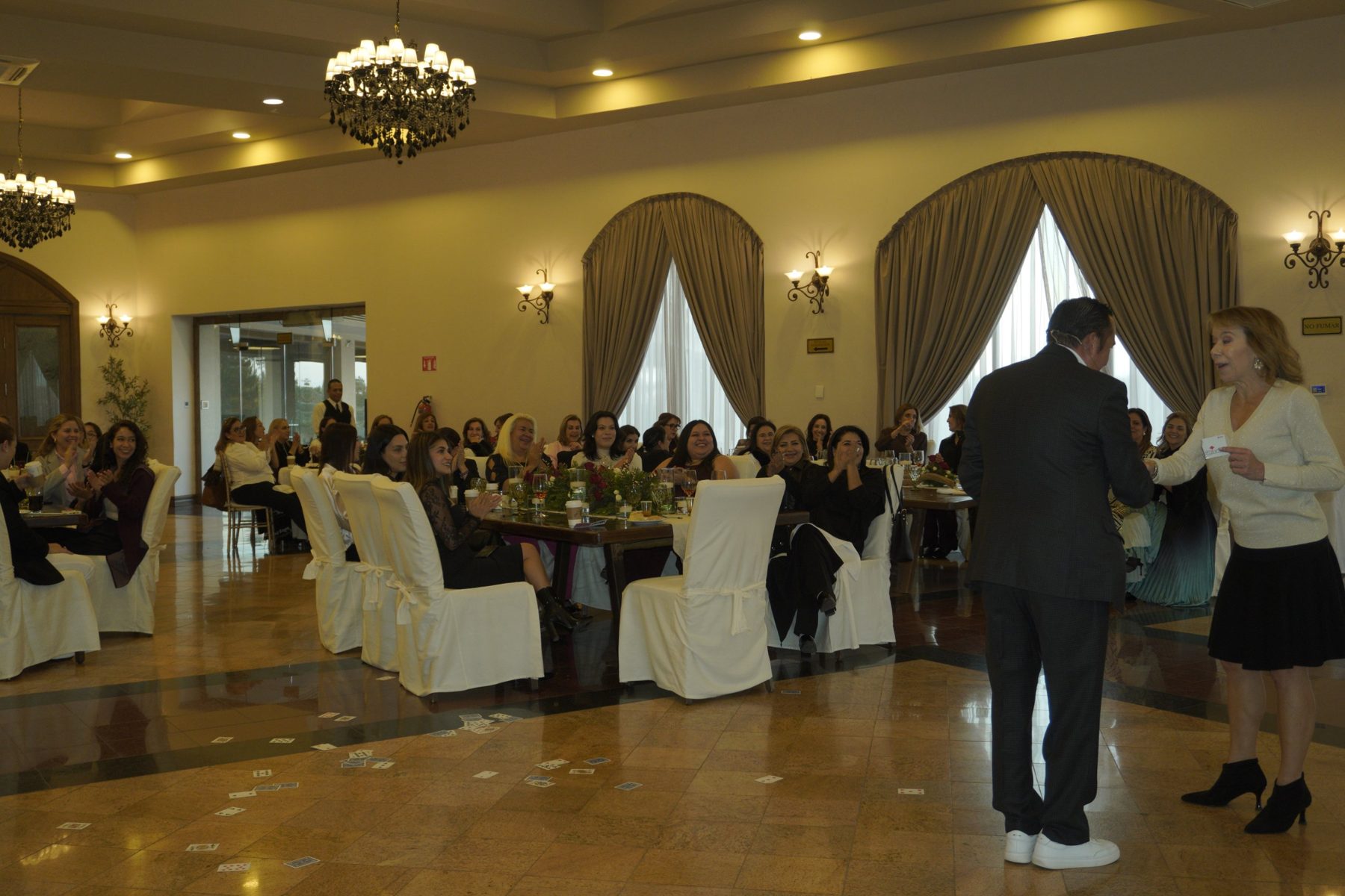 Una asistente recibe una carta mientras el salón aplaude